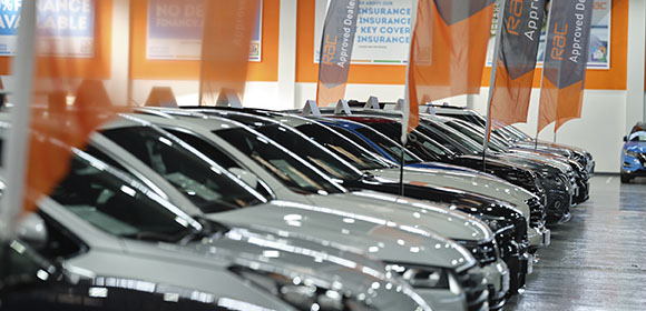 a car showroom with many cars in a row