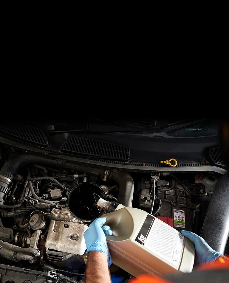 A close up of car being topped up with oil