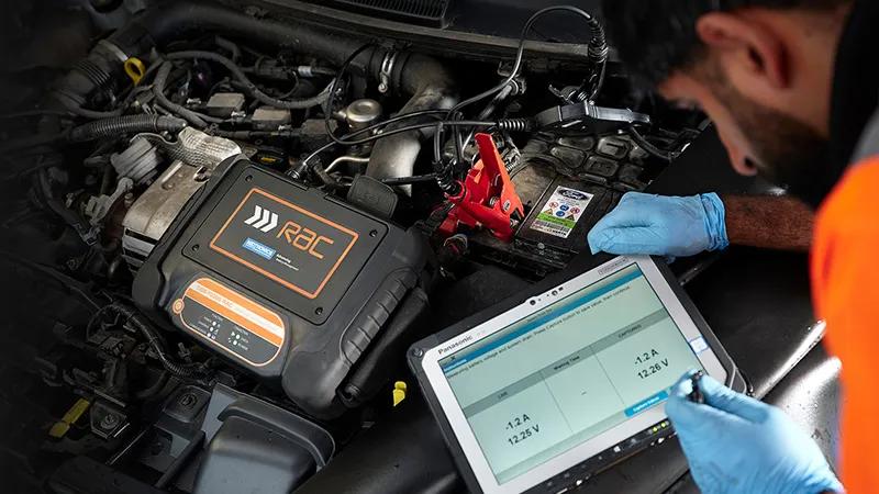 A mechanic inspecting a car battery.