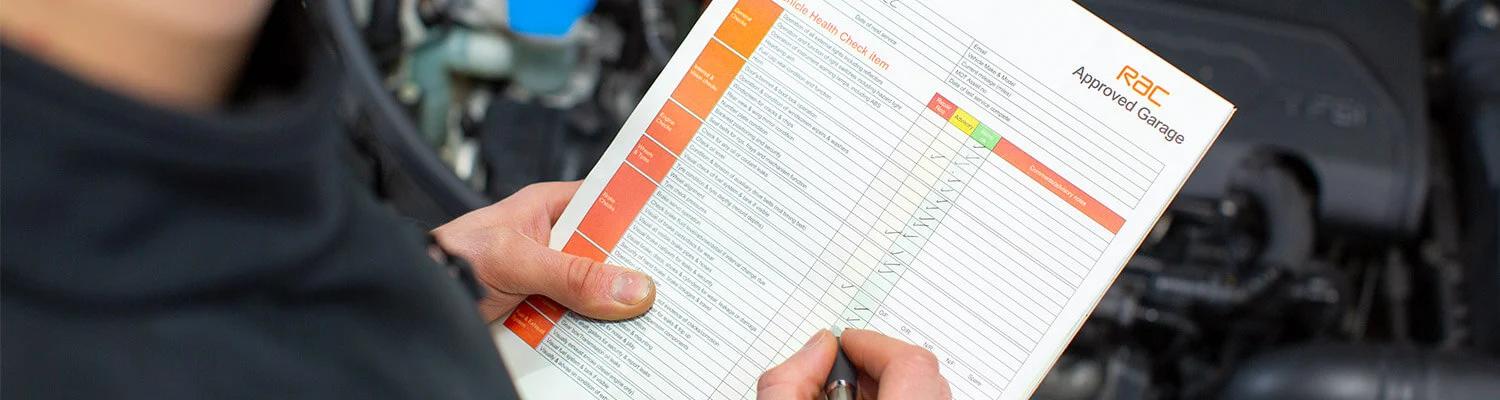 Close up of a person holding a vehicle health check form