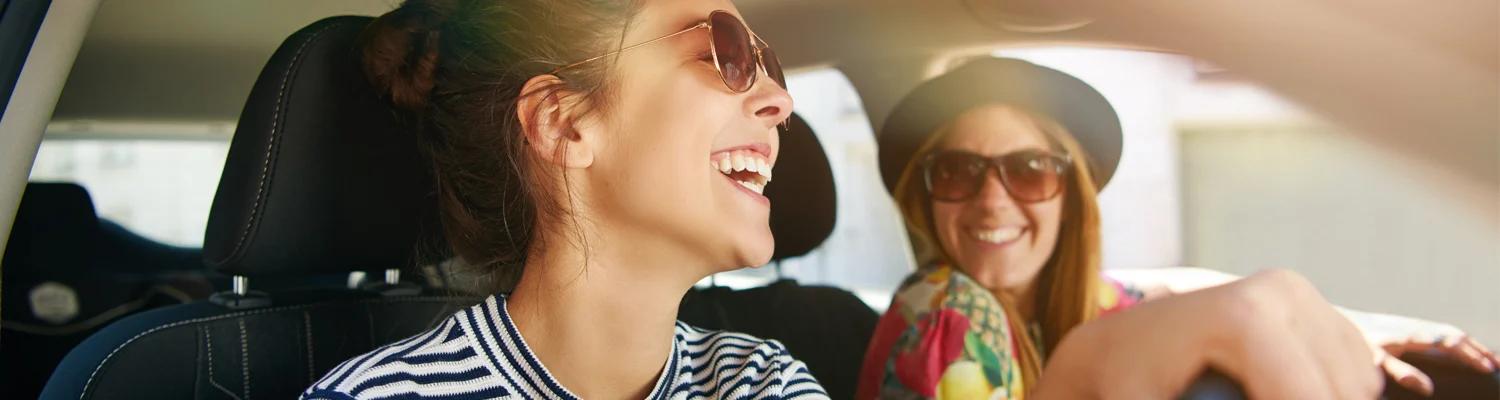 Two young women laughing in a car