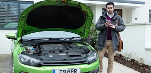 Man stood next door to his car with the bonnet open