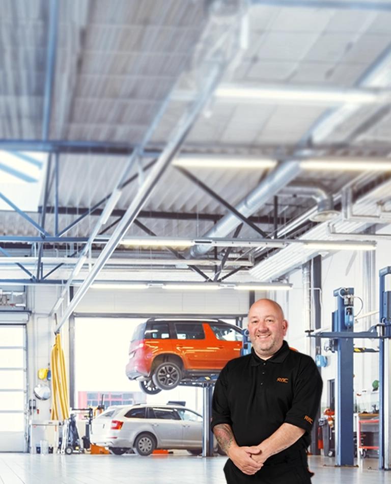 A mechanic standing inside a garage.