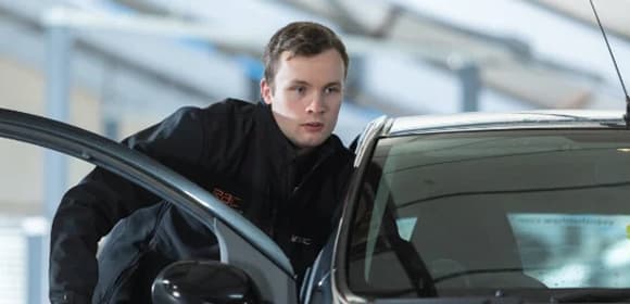 Mobile mechanic stood next to a car