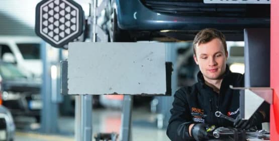 Mechanic stood under a car