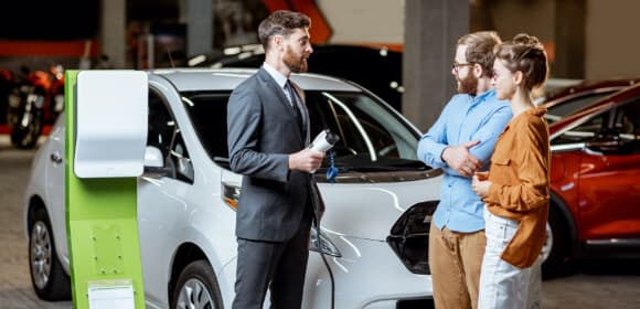 Sales person speaking with young couple about EV's