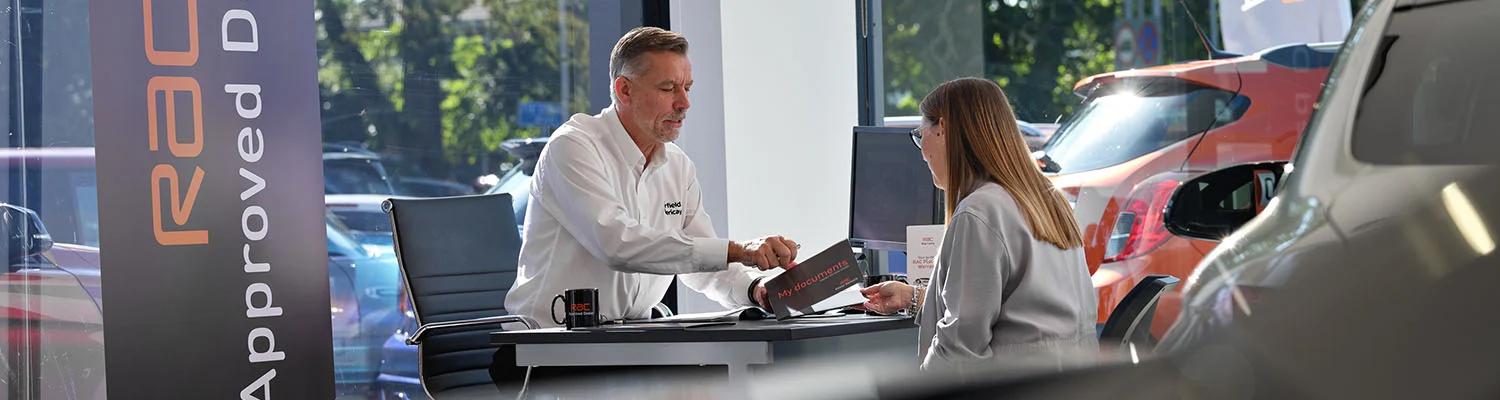 Approved dealer talking to a lady who has just purchased a car