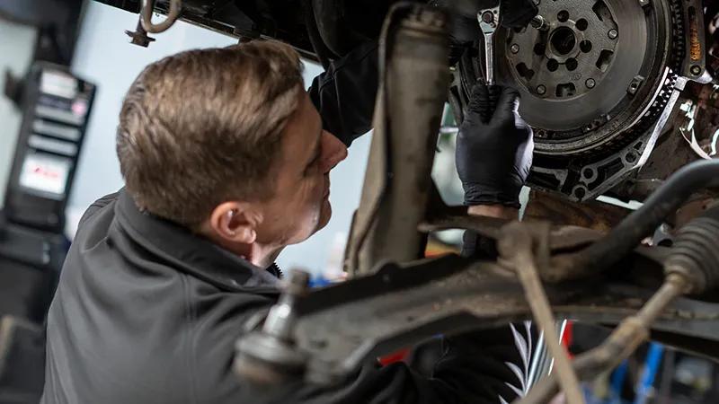 A close up of a mechanic inspecting a car