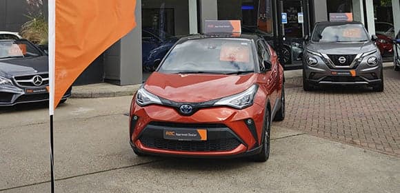 Orange car parked outside a showroom