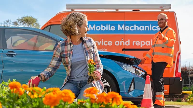 A customer tending to her garage with an RAC Mobile Mechanic in the background