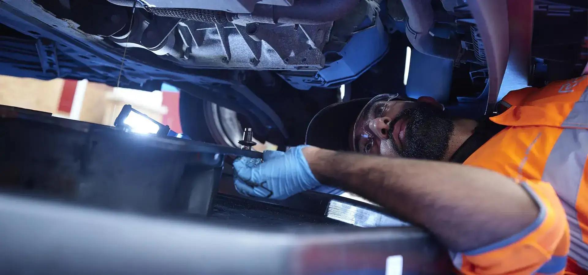 An RAC Mobile Mechanic inspecting the underside of a vehicle.