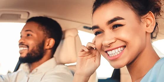 two smiley, happy people in a car together