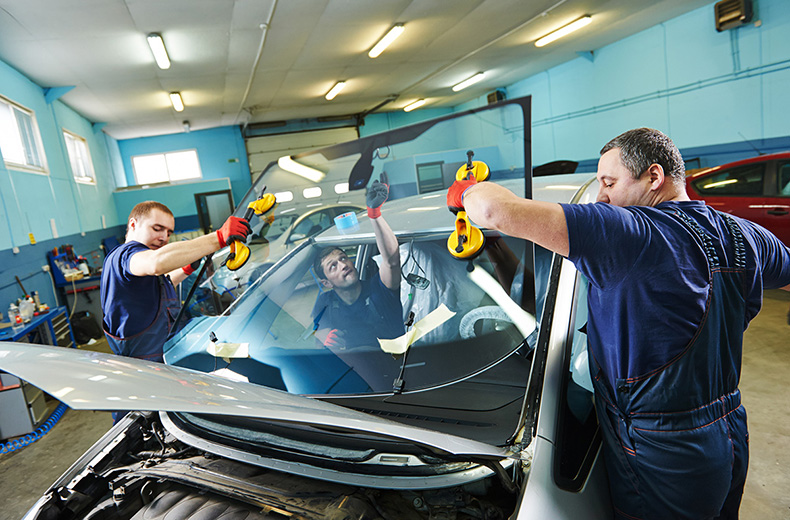 team of mechanics replacing windscreen