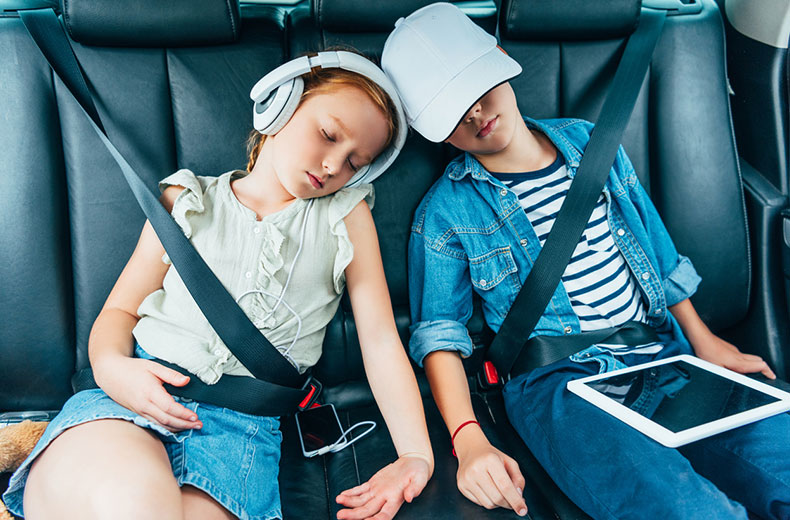 two children asleep in backseat of car