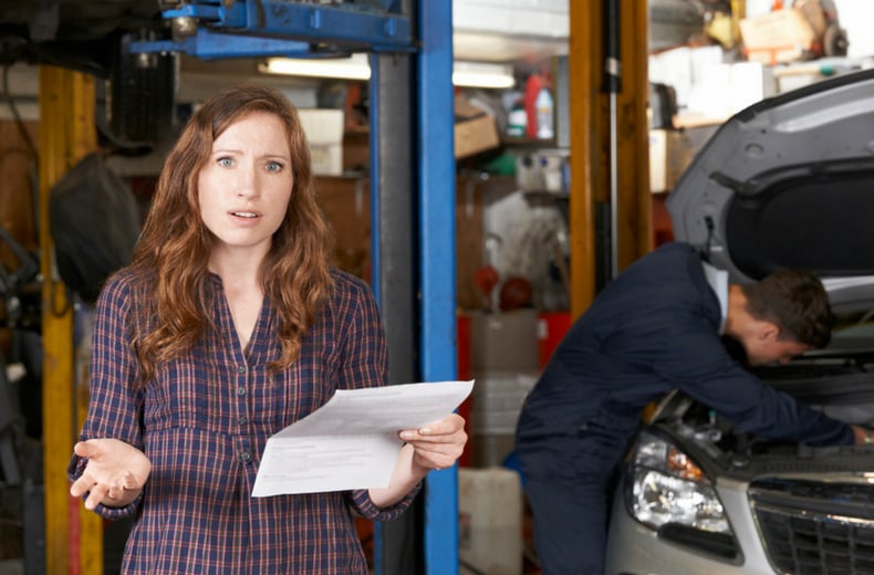 woman looking confused by mechanic bill