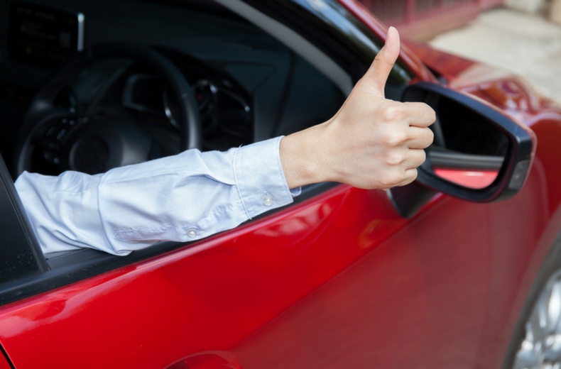 man sticking thumbs up out car window